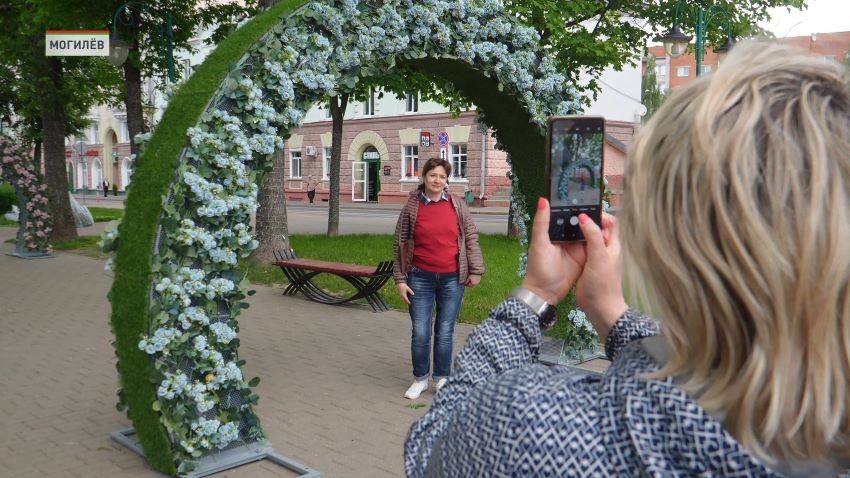 Могилев бьет цветочные рекорды. В этом сезоне город украсят более 1 миллиона 300 тысяч саженцев, сообщили в программе «Беларусь. Новости». Смена красок происходит несколько раз в год. Сначала жителей радуют тюльпаны и гиацинты, а уже после – бархатцы, петунии и бегонии. Для флористов это кропотливая работа. Помимо привычных клумб они создают и необычные элементы: от вертикальных полотен, до целых цветущих мостов. Марина Новикова, заместитель начальника производственно-технического отдела коммунального предприятия «Могилевзеленстрой»: Добавляются новые композиции, уже все расцвело очень красиво. Из нового у нас добавляются в Театральном сквере женщины с юбками. Будут цветочные юбки. Труд очень тяжелый, но когда выезжаешь в город, конечно, глаза радуются. Очень ярко, красиво, очень много локаций для фотографий. Яркие элементы появились в каждом уголке Могилева. Так, площадь Звездочета украсила цветочная аркада, а в Комсомольском сквере установили шесть Арок. Теперь у жителей появилась новая локация для фото