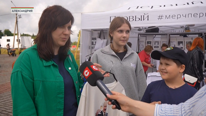 Мы сюда приезжаем каждый год уже на протяжении лет четырех. Каждый год мы не проходим мимо этой палатки с «Мерчом Первого». И каждый год мы отсюда увозим какой-то сувенир. В этом году мы решили приобрести майку. Мы уже приобрели сумочку – шопер вот тоже «Первый», «Мерч Первого». Поэтому сегодня тоже уедем не с пустыми руками. 