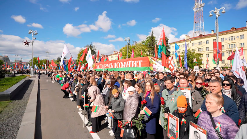 Сотни человек идут по Проспекту Независимости, чтобы почтить память героев Великой Отечественной войны и возложить цветы к Вечному огню и монументу Победы.